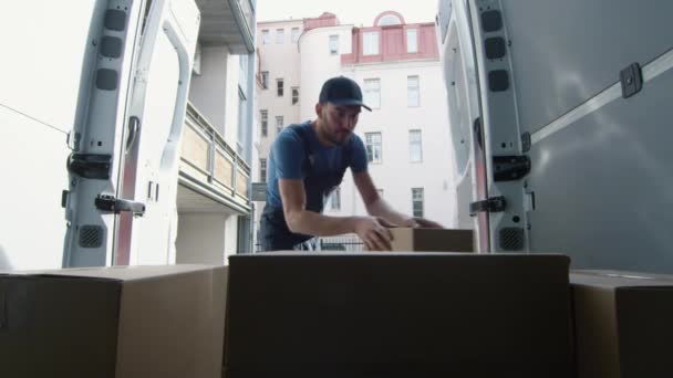 Lader packt große Kisten in sein Nutzfahrzeug. Schuss aus dem Inneren des Transporters. — Stockvideo