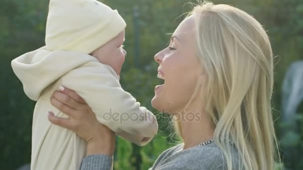 Moeder kussen haar Baby terwijl Lying op het gras. — Stockvideo