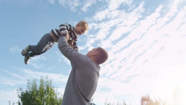 Отец подбрасывает своего сына в воздух . — стоковое видео
