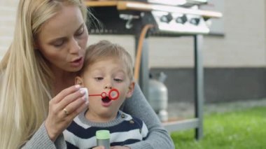 Anne ve çocuk sabun balonları patlat.