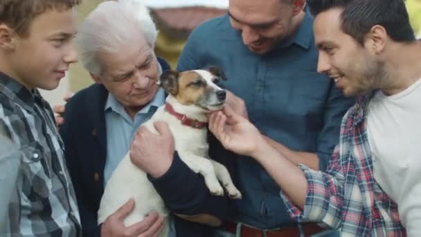Membros de uma grande família brincam com seu cachorro . — Vídeo de Stock