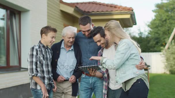 Personas de varias edades utilizan tabletas durante la reunión familiar — Vídeo de stock