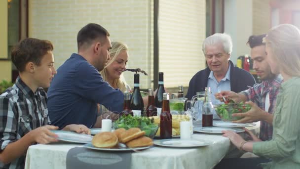 Gruppo di persone di razza mista Divertirsi, comunicare e mangiare alla cena di famiglia all'aperto — Video Stock