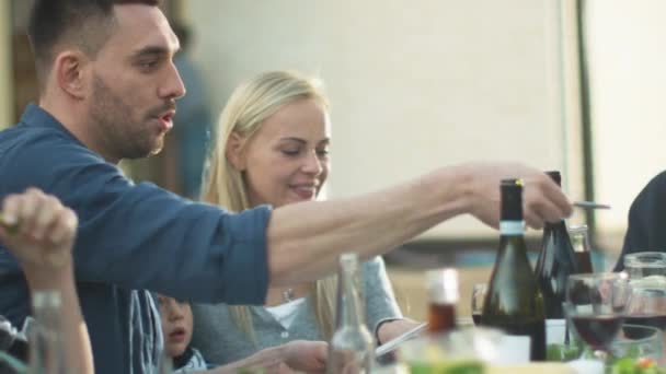 Groupe de personnes de race mixte qui s'amusent, communiquent et mangent au dîner familial en plein air 