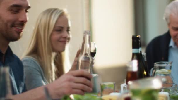 Grupo de personas de raza mixta divirtiéndose, celebrando y levantando vasos en la cena familiar . — Vídeos de Stock