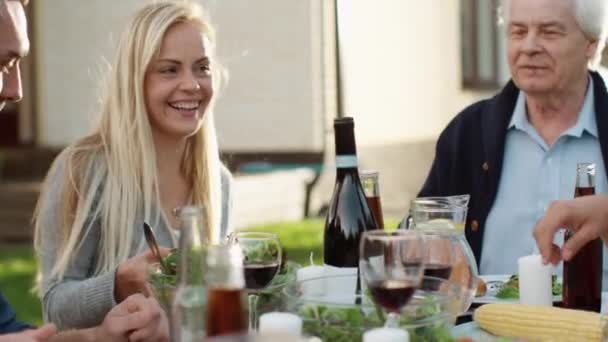Grupo de pessoas de raça mista se divertindo, se comunicando e comendo no jantar de família ao ar livre — Vídeo de Stock