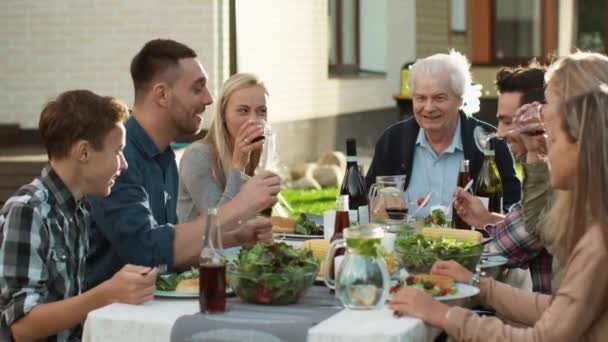 Grupp av blandad ras människor att ha kul, kommunicera och äter utomhus familjemiddag — Stockvideo