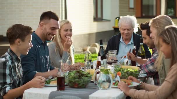 Grupo de personas de raza mixta divirtiéndose, comunicándose y comiendo en la cena familiar al aire libre — Vídeos de Stock