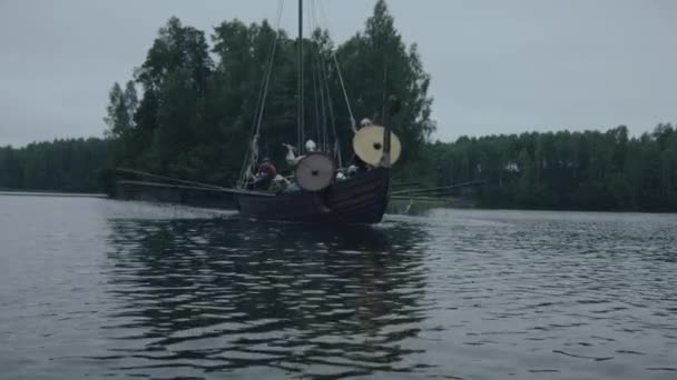 Viking bojovníci na řadě lodi dorazí na břeh. Festival Vikingové a Slovany. Středověká rekonstrukce.