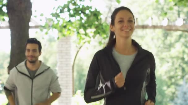 Fiatal férfi és nő fut össze, a világos napos Park. — Stock videók