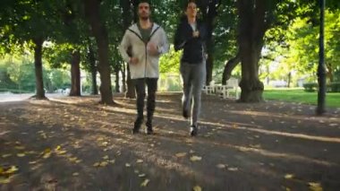 Genç kadın ve birlikte ileriye doğru kamera parlak güneşli bir günde koşan adam