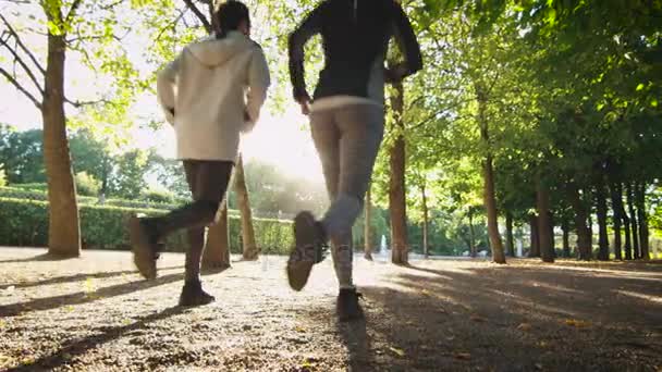 Молодая женщина, бегущая вперед за пределы камеры в яркий солнечный день — стоковое видео