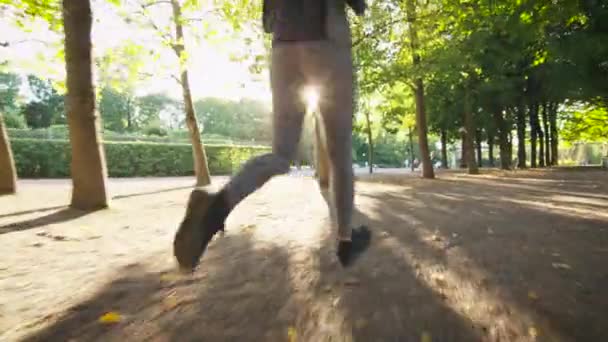 Takip atış kadın ve dışa doğru ileri dışa doğru kamera parlak güneşli bir günde koşan adam — Stok video