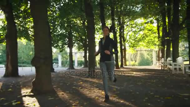 Mujer joven y hombre corriendo juntos hacia delante hacia la cámara en un día soleado brillante — Vídeos de Stock