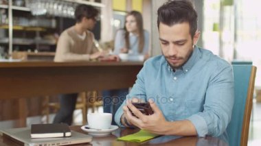 İspanyol elbise genç sıcak kahve dükkanında cep telefonu kullanan adam.