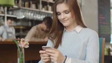 Çekici genç kadın sıcak kahve dükkanında istimal hareket eden telefon.