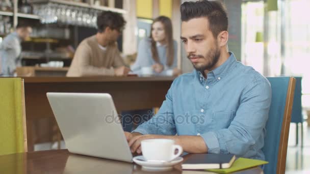 Hispán etnikai fiatalember Laptop számítógép használata a hangulatos kávézóban. — Stock videók