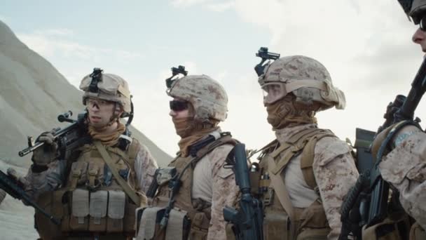 Le Groupe de soldats est debout dans un cercle et écoute les ordres du commandant lors d'une séance d'information avant l'opération militaire dans le désert. Mouvement lent . — Video