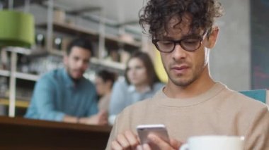 İspanyol elbise genç sıcak kahve dükkanında cep telefonu kullanan adam.