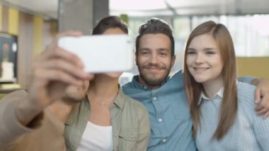 Grup genç gülümseyen karışık ırk insanlar Selfie telefonu kafede ile yapıyor.