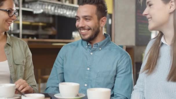 Gruppe positiver gemischter Rassen junger Leute unterhält sich im Café. — Stockvideo