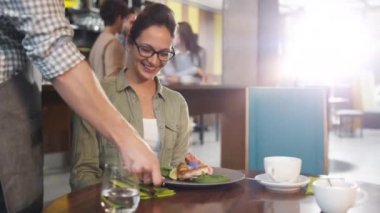 Lezzetli balık biftek çekici genç kadın için restoranda getiren garson.