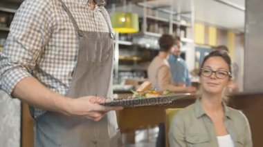 Çekici genç kadın restoranda lezzetli bir balık biftek getiren garson.