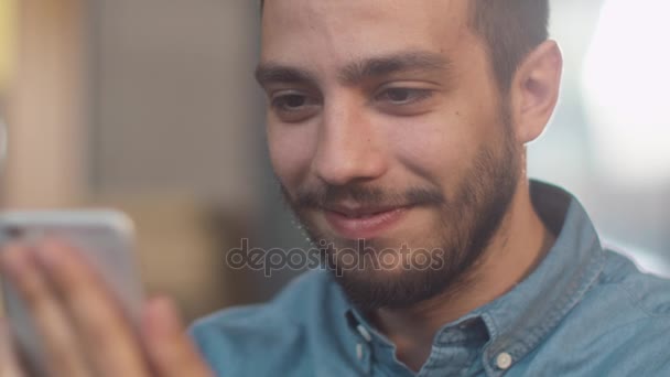 Іспаномовні етнічної приналежності юнак за допомогою мобільного телефону в затишному кафе. — стокове відео