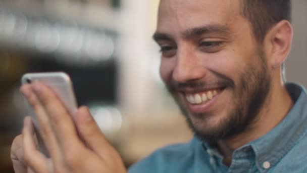 Hombre joven de etnia hispana usando teléfono móvil en la acogedora cafetería . — Vídeo de stock