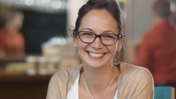 Retrato de la atractiva joven sonriente en la acogedora cafetería . — Vídeos de Stock