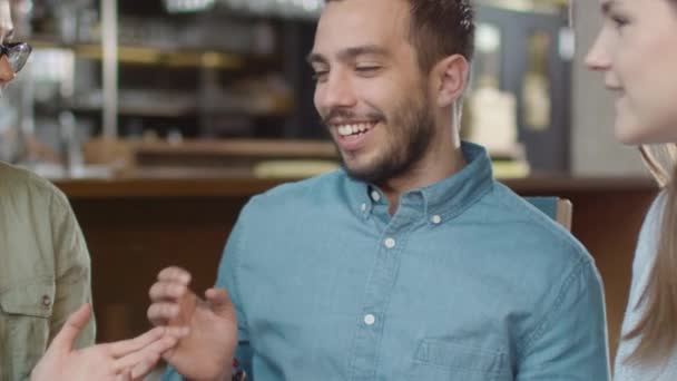 Група позитивної змішаної раси Молоді люди розмовляють у кав'ярні . — стокове відео