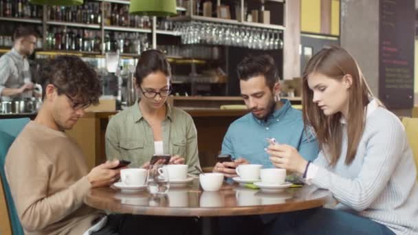 Grup de tineri de curse mixte Oameni care folosesc telefoane în cafenea . — Videoclip de stoc