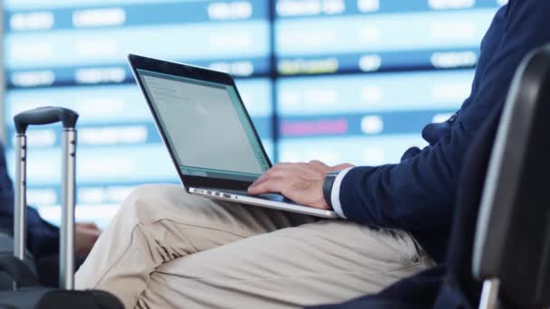 Uomo che lavora al computer portatile in attesa di imbarcarsi presso la sala partenze dell'aeroporto . — Video Stock