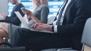 Laptop süre bekleyen yatılı havaalanında gidiş salonunda çalışan iş adamı.