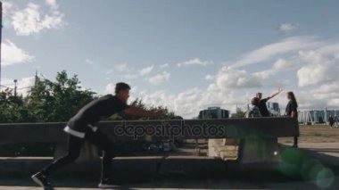 Genç erkek Freerunner hileler ve açık havada kentsel ortamda atlar.