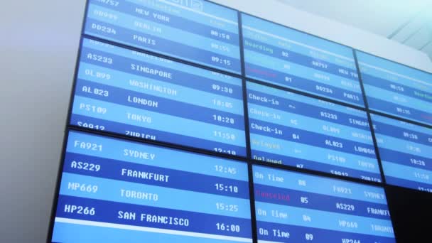 Business mensen lopen naast het informatiebord op de luchthaven. — Stockvideo