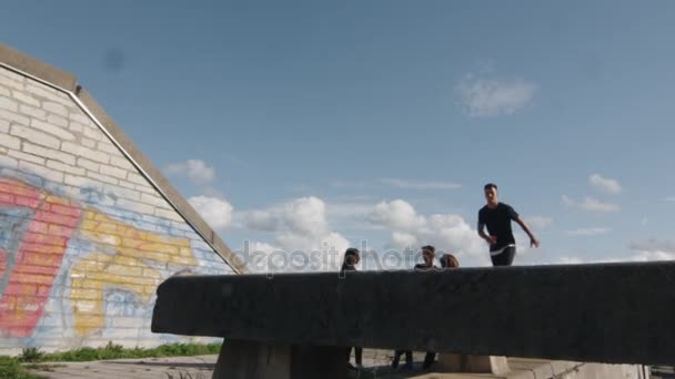 Junge männliche Freerunner zeigen Tricks und Sprünge im Freien in urbaner Umgebung. — Stockvideo