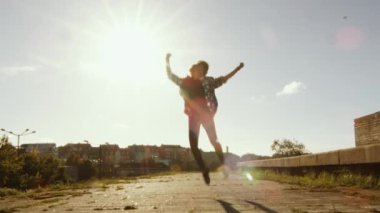 Genç mutlu genç kız çalıştıran ve yapıyor kutlama atlama açık havada.