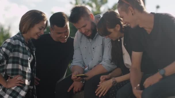 Grupp tonåringar använder mobiltelefon för underhållning utomhus i stadsmiljö — Stockvideo