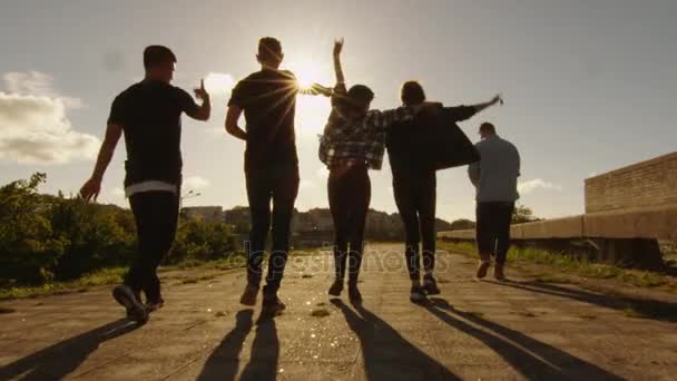 Groupe d'adolescents heureux riant, levant les mains, sautant tout en se déplaçant vers l'extérieur caméra . — Video