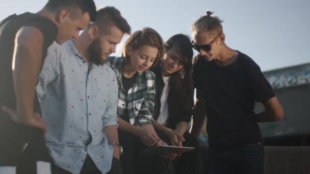 Groep tieners met behulp van Tablet PC voor Entertainment buitenshuis in stedelijke omgeving — Stockvideo