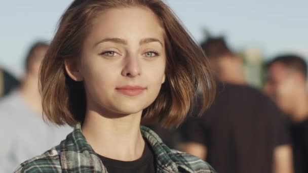 Portret atrakcyjna młoda dziewczyna patrząc na kamery, uśmiech i śmianie się na zewnątrz w środowisku miejskim. — Wideo stockowe