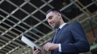 İşadamı ve Tablet bilgisayar kullanarak. Cam binası veya gökdelen üzerinde arka plan yapım aşamasında.