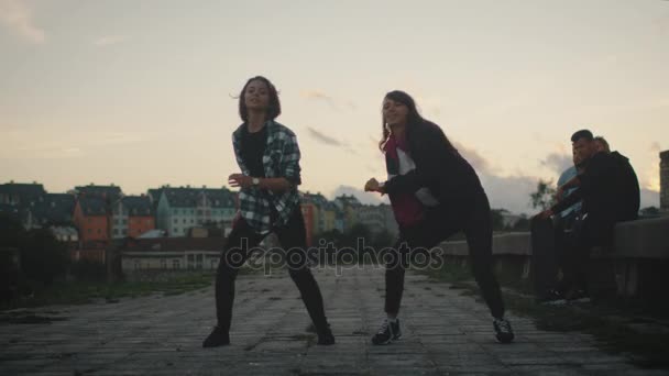 Deux jeunes adolescentes exécutant la danse moderne pour leurs amis sur un bâtiment abandonné . — Video