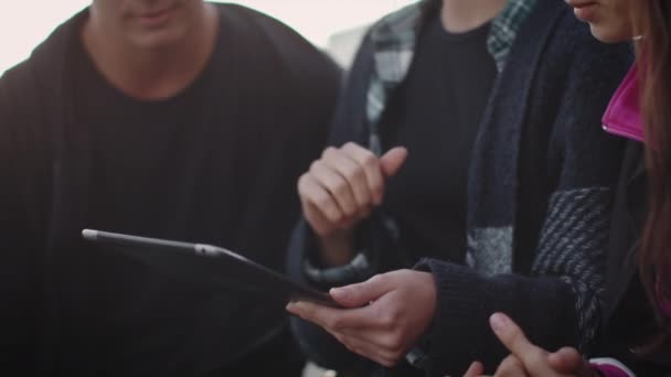 Grupo de adolescentes sonrientes y rientes que usan Tablet Computer para entretenimiento al aire libre en entornos urbanos. Primer plano de disparo . — Vídeo de stock