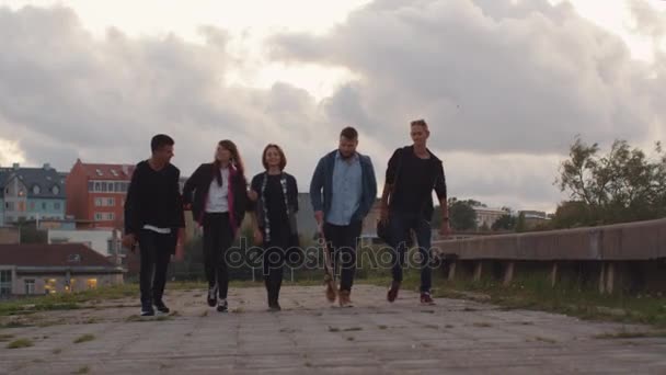 İleri kentsel ortamda kameraya doğru yürüyüş beş mutlu genç grup. — Stok video