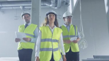 Grup mühendis yürüyüş ve binanın yapım aşamasında içinde konuşmak zor şapka.