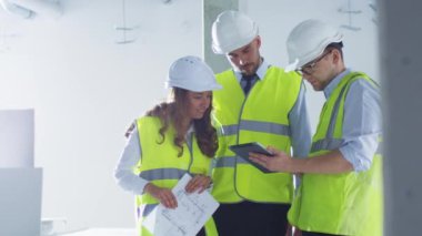 Grup mühendis konuşmayı, Tablet bilgisayar, binanın yapım aşamasında içinde seyir zor şapka.