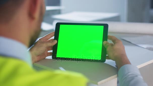 Інженер тримає планшетний комп'ютер з зеленим екраном всередині будівлі під будівництвом. Відмінно підходить для використання Mockup . — стокове відео