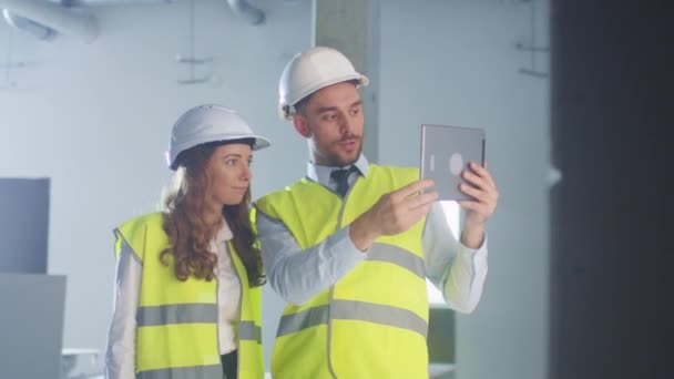 하드 모자에 두 엔지니어는 증강 현실에 대 한 태블릿 컴퓨터를 사용 하는. — 비디오